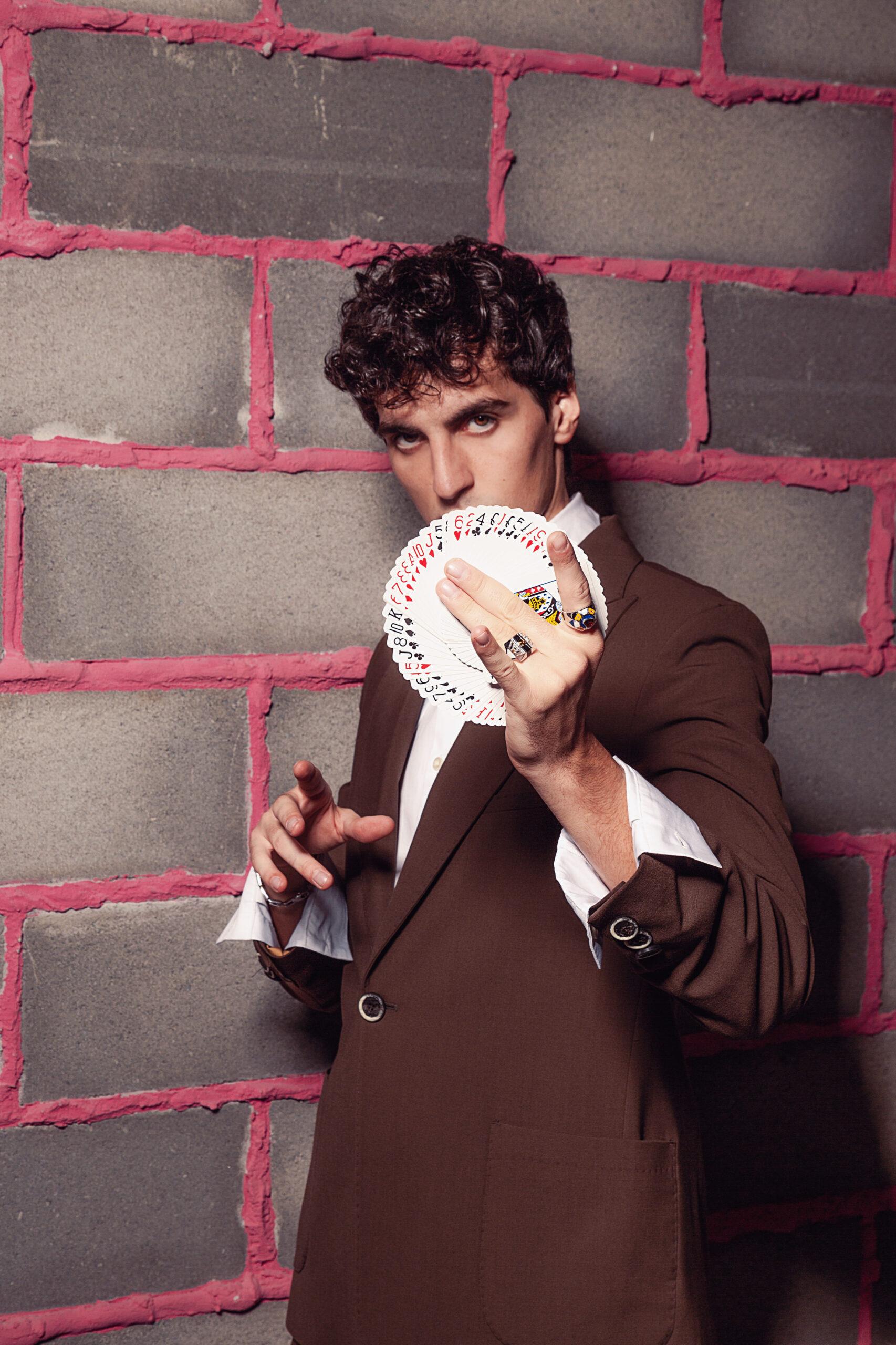 uomo che guarda in camera con un mazzo di carte in mano