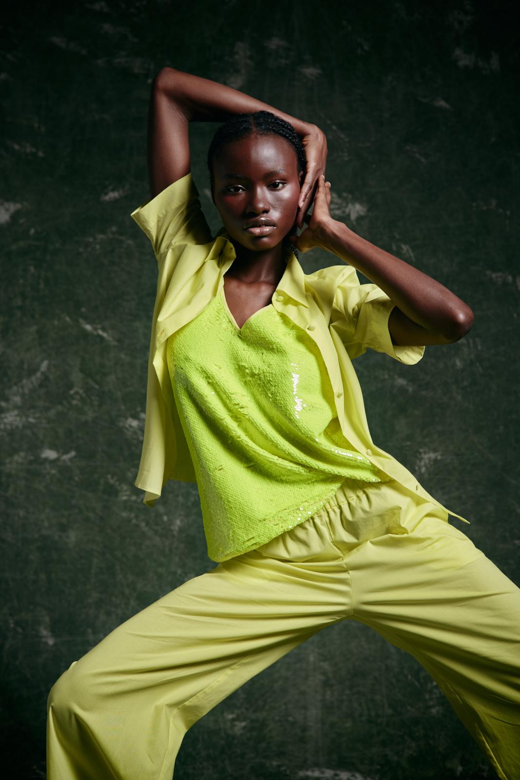 modella  di colore indossa outfit verde lime