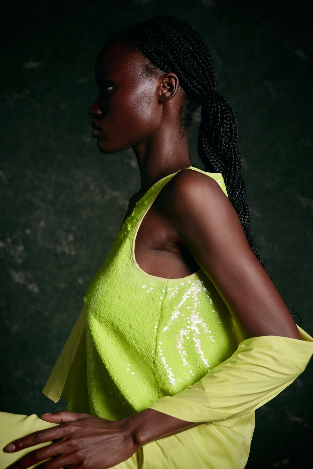 modella di colore di profilo con outfit verde lime