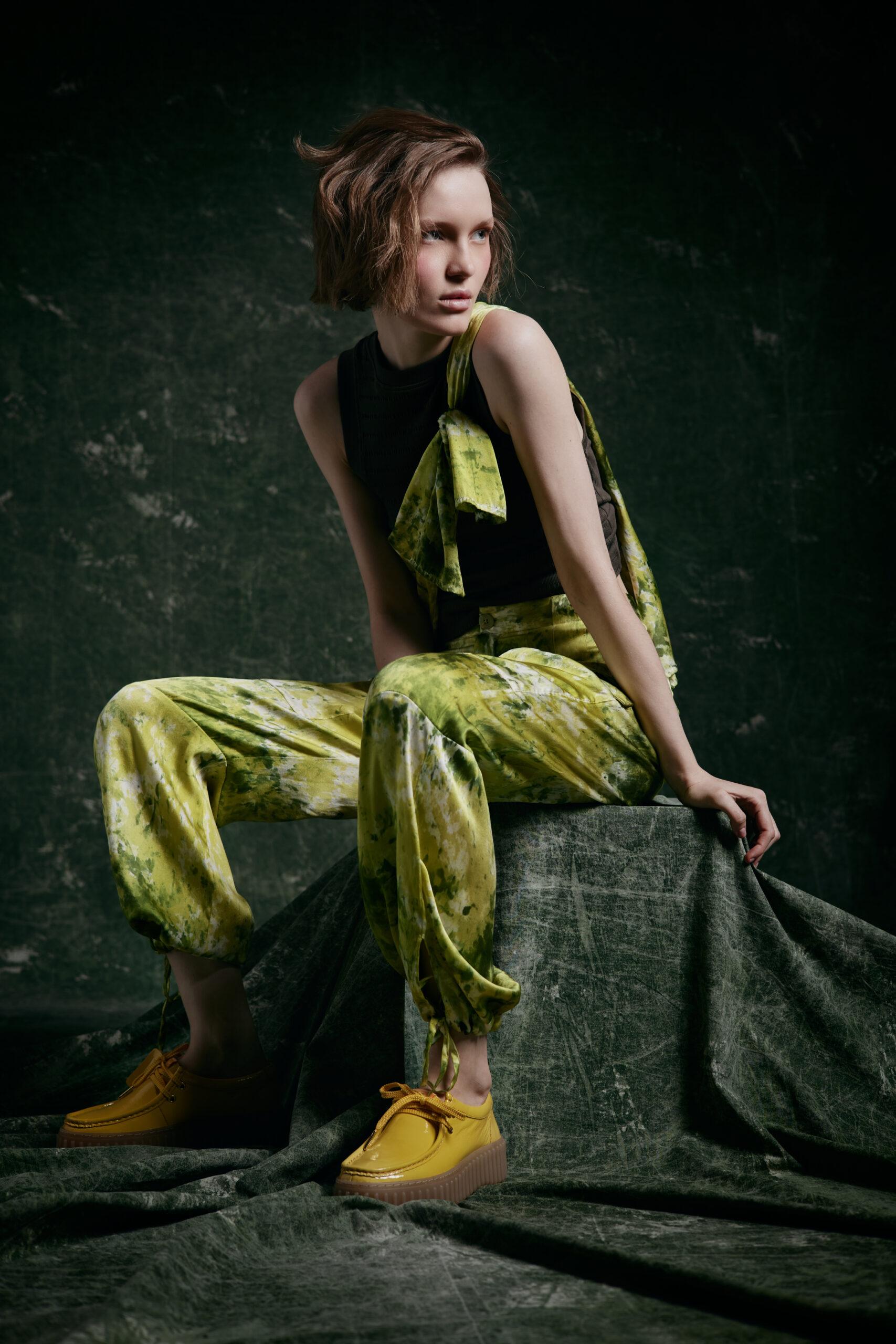 modella bionda seduta
outfit di seta verde stampata stilo batik