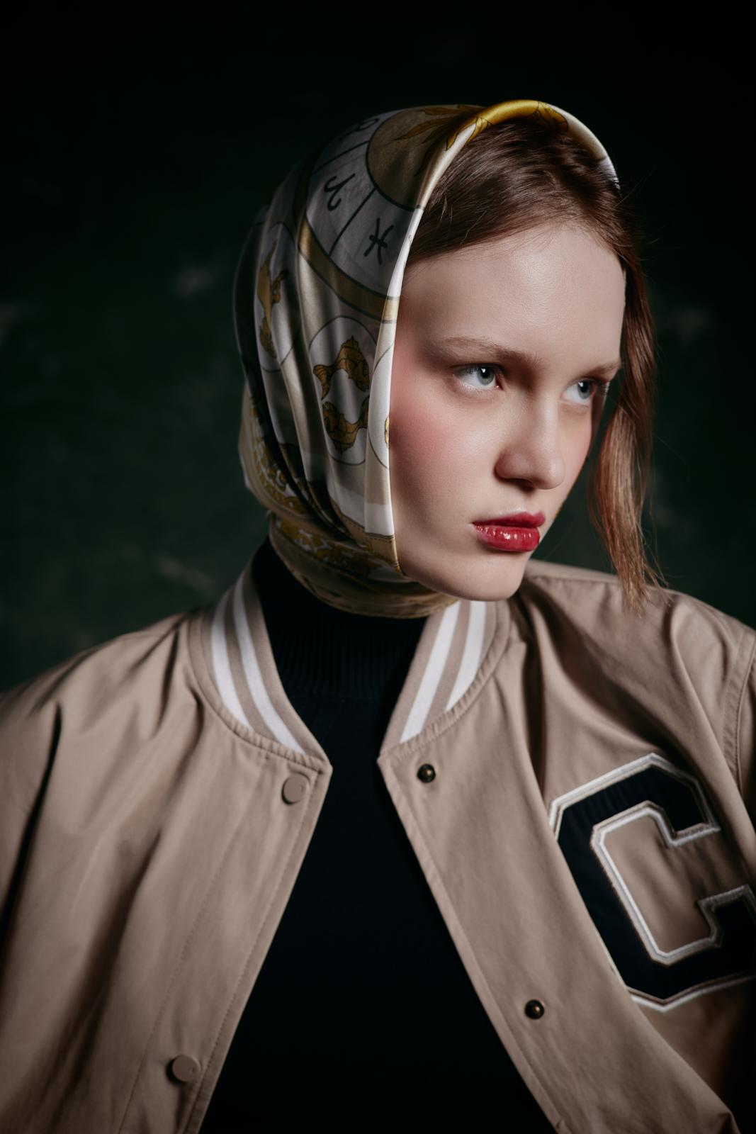 modella bionda con giacca bomber e foulard di seta in testa