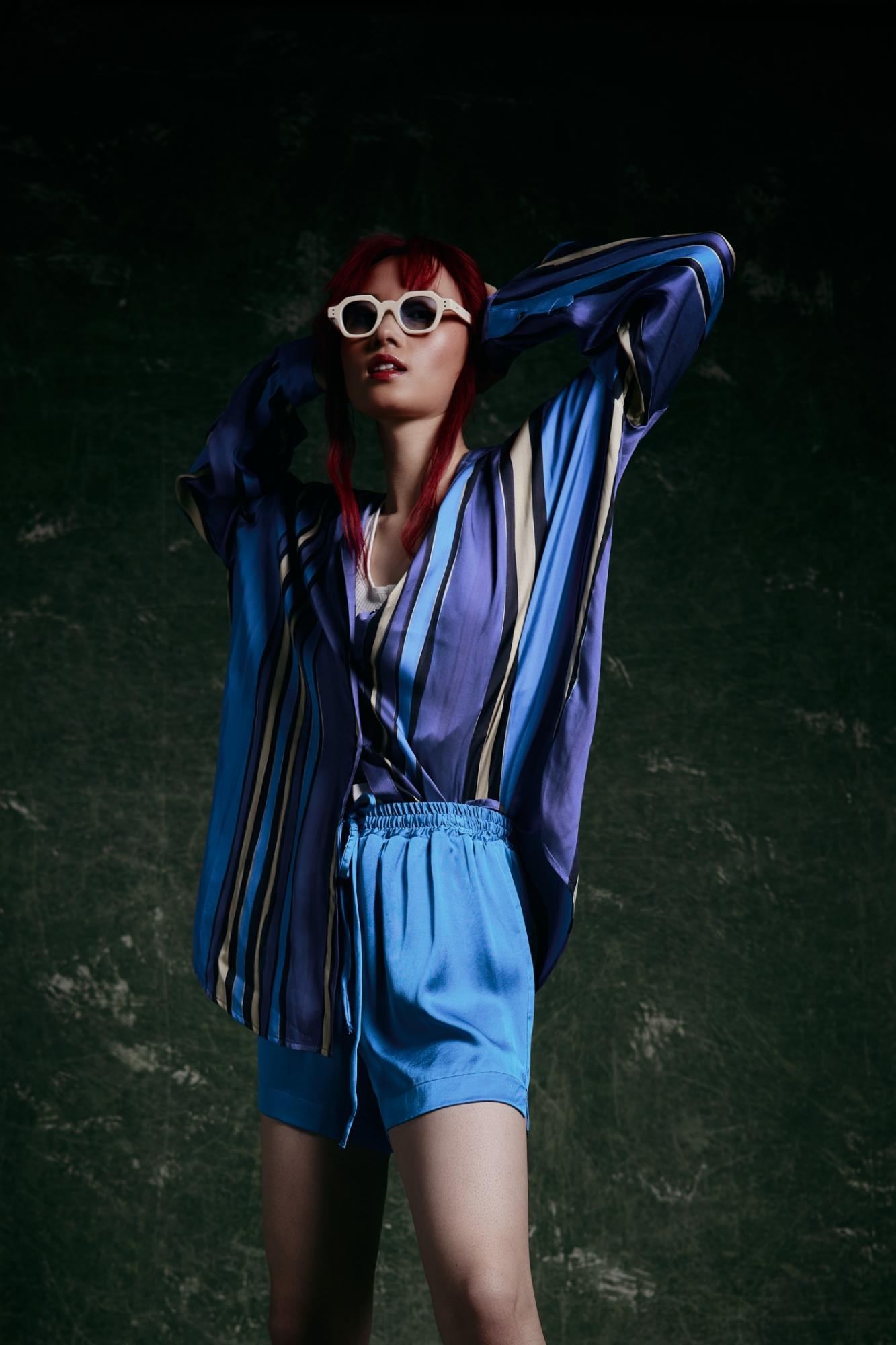 modella cinese con capelli rossi e occhiali da sole
outfit di seta blu stampato